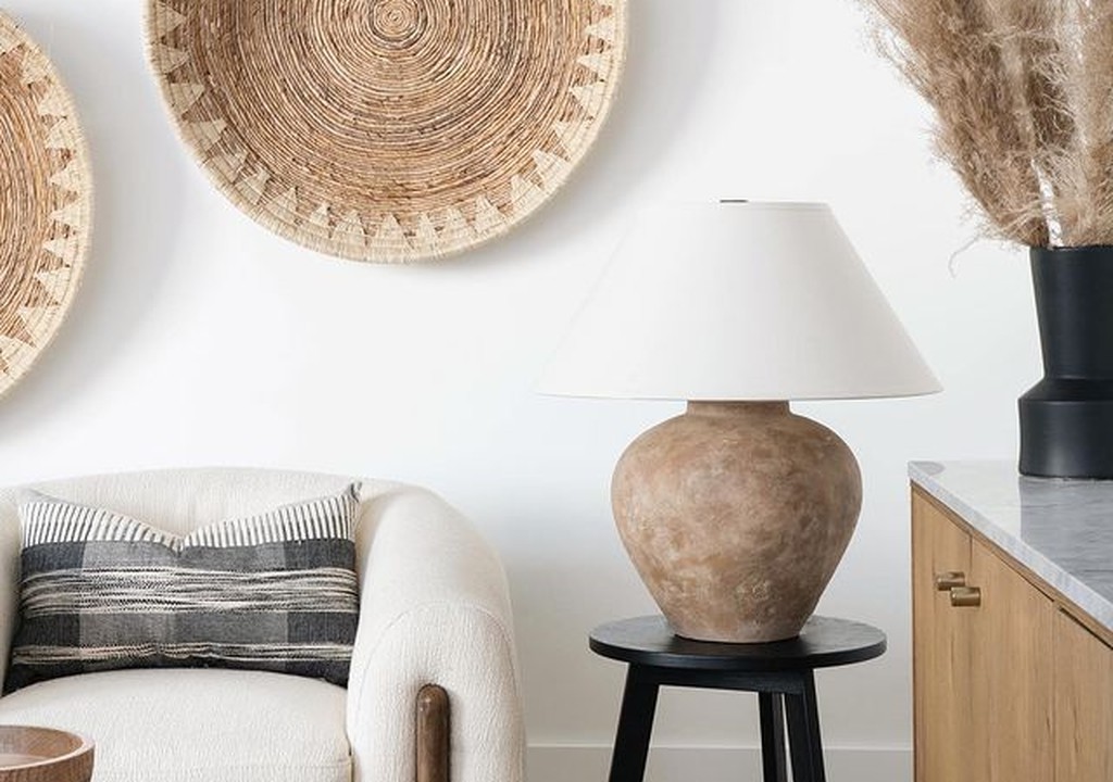 Sala con sofá en tonos neutros, lámpara de mesa y cestas de mimbre