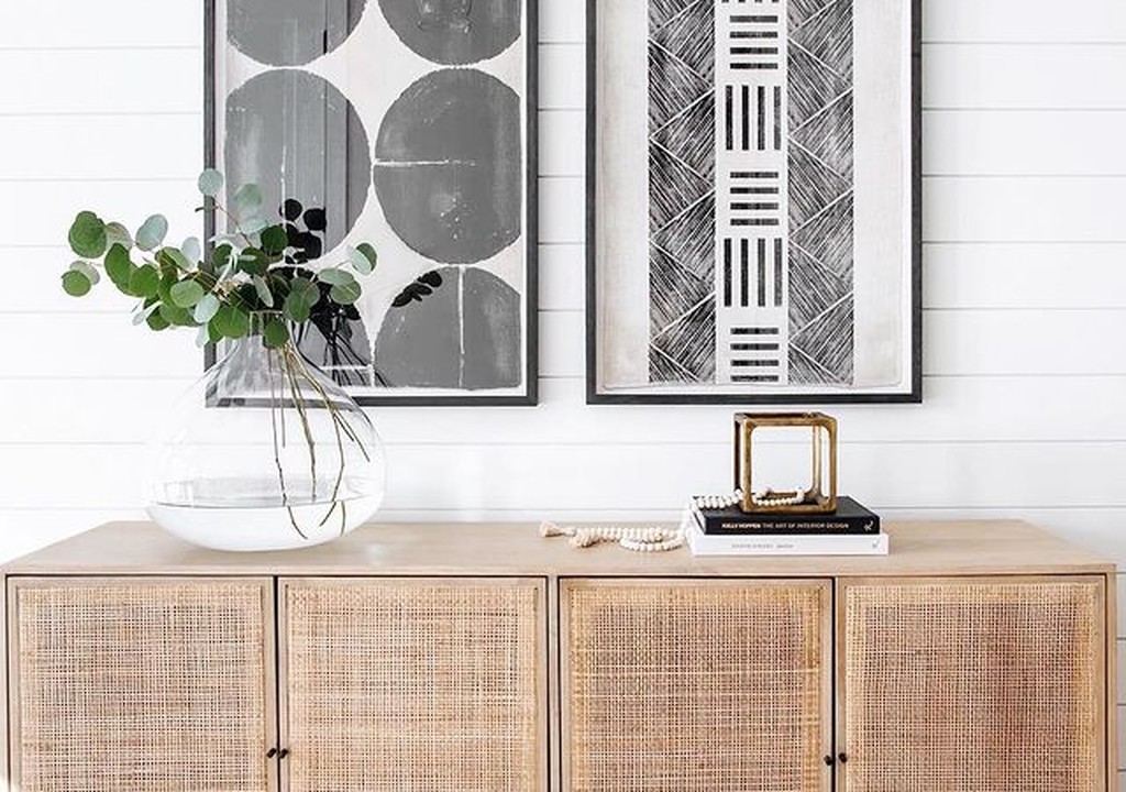 Mueble de madera con plantas y cuadros decorativos